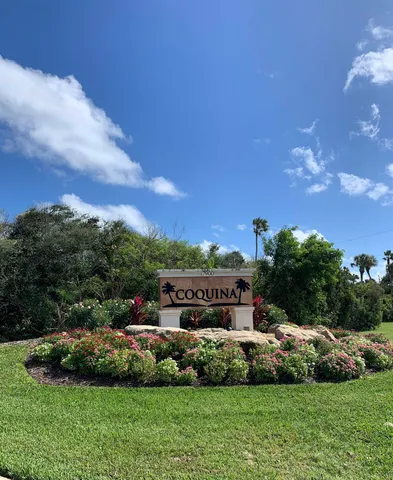 a front view of a house with a garden and trees
