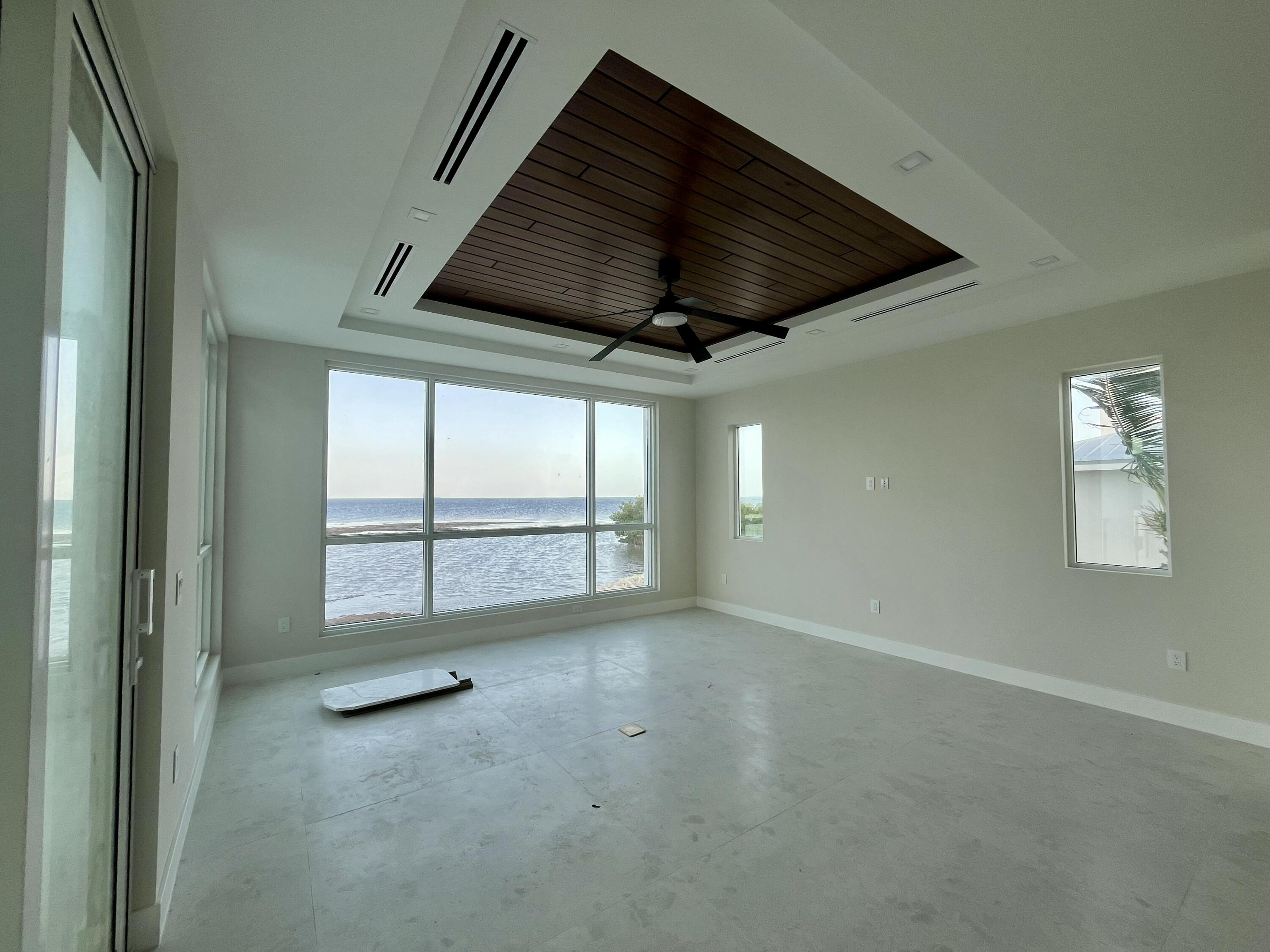 128 Sunrise Drive Marathon, FL 33050 - Photo 8 of 40 an empty room with windows and ceiling fan