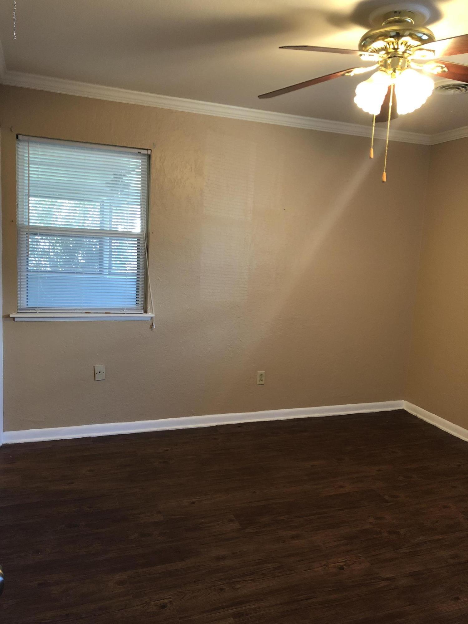 2406 Southwest 49th Avenue Amarillo, TX 79110 - Photo 20 of 38 a view of an empty room with wooden floor and a window