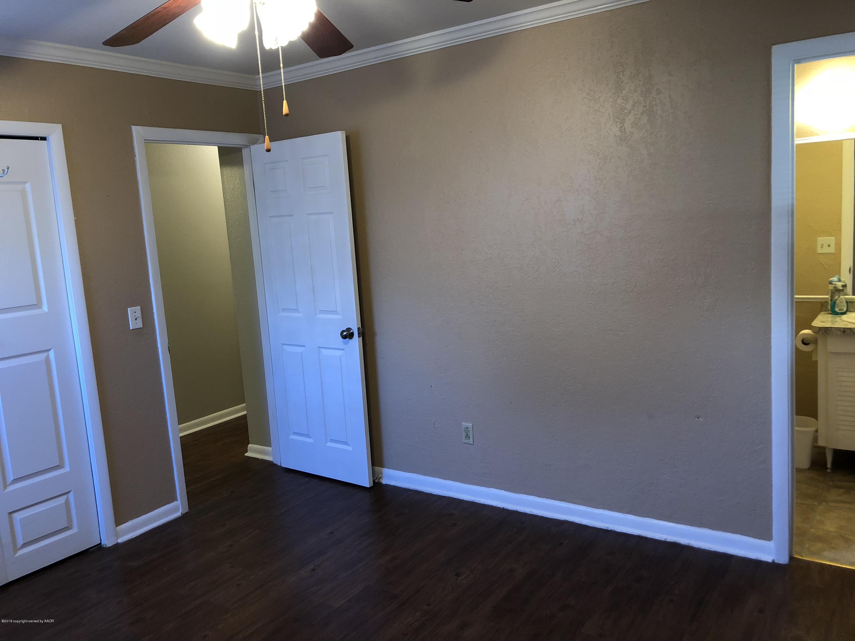 2406 Southwest 49th Avenue Amarillo, TX 79110 - Photo 22 of 38 an empty room with wooden floor and chandelier fan
