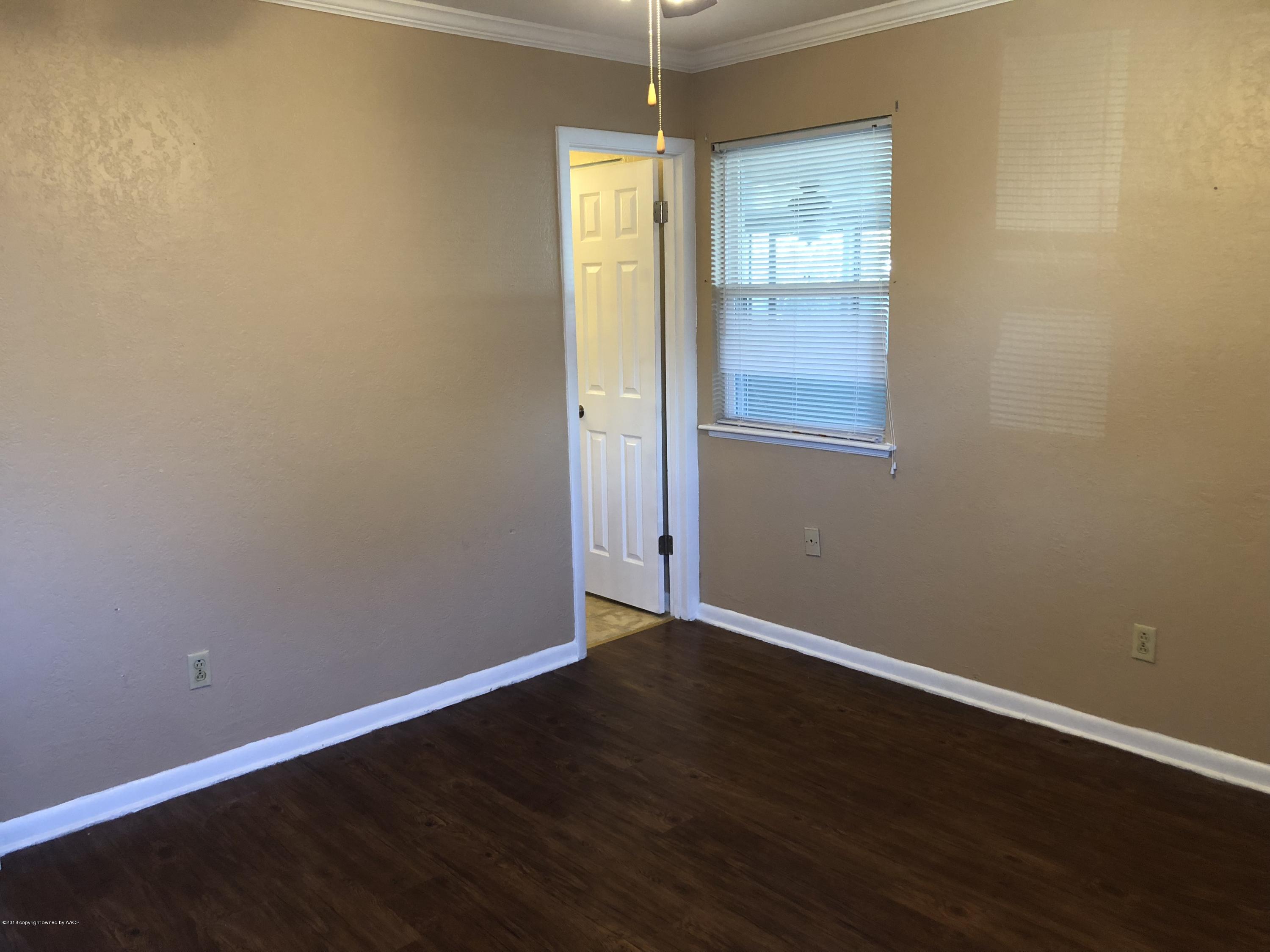 2406 Southwest 49th Avenue Amarillo, TX 79110 - Photo 24 of 38 an empty room with wooden floor and windows