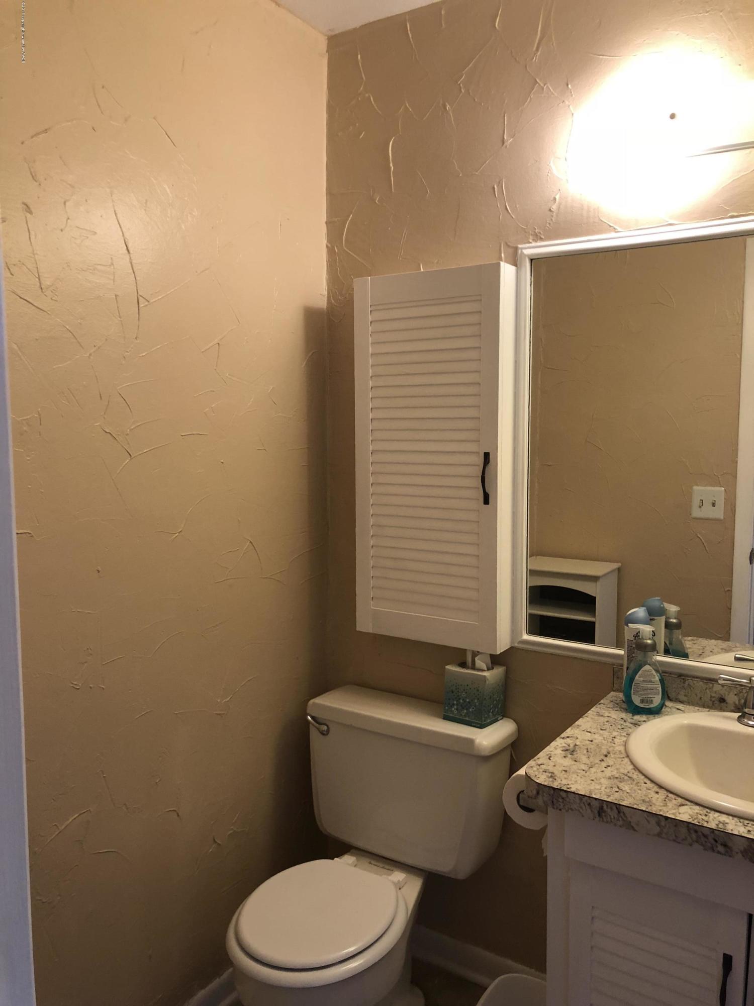 2406 Southwest 49th Avenue Amarillo, TX 79110 - Photo 25 of 38 a bathroom with a granite countertop toilet a sink and a mirror