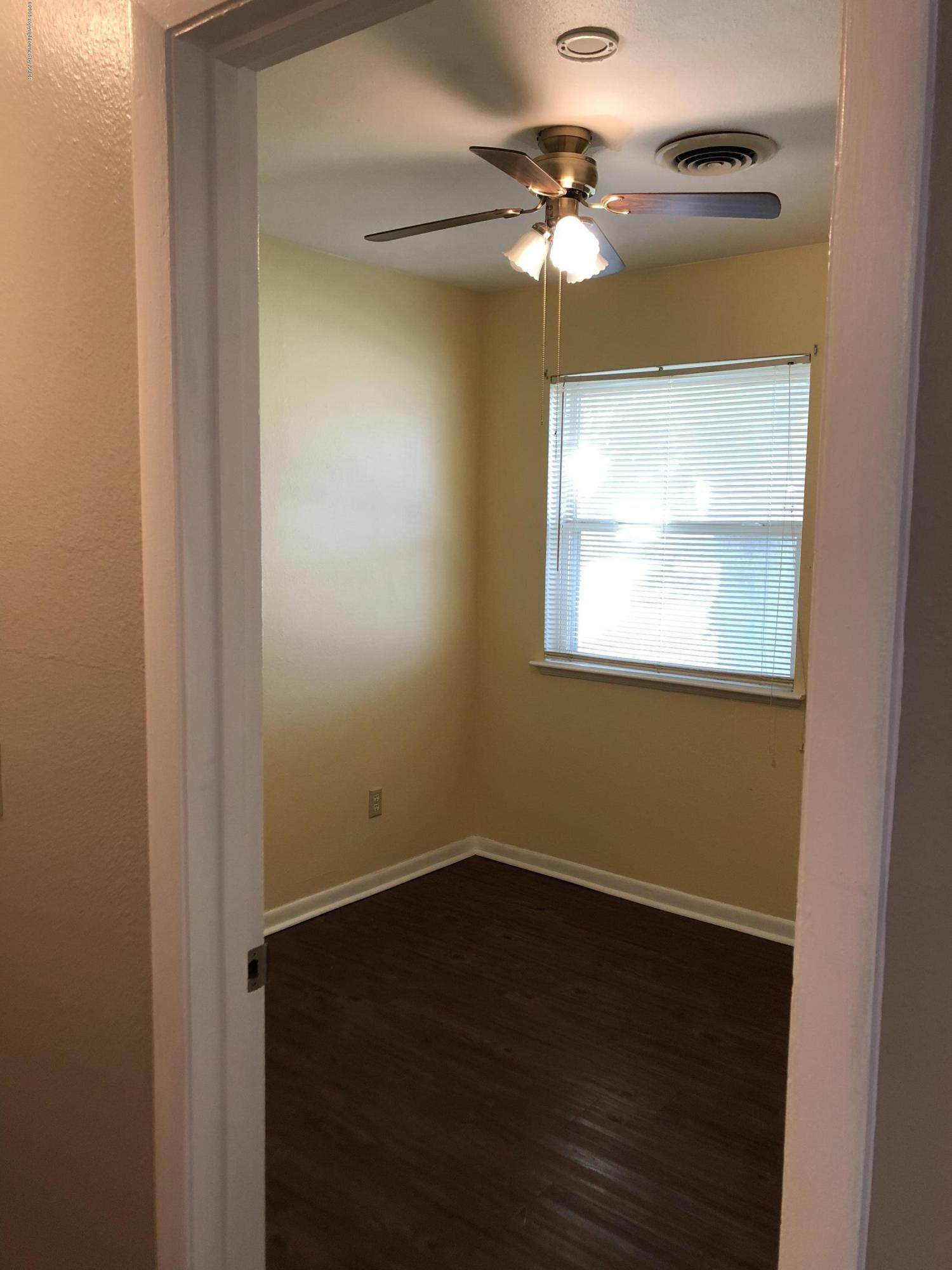 2406 Southwest 49th Avenue Amarillo, TX 79110 - Photo 27 of 38 an empty room with a chandelier fan and a window