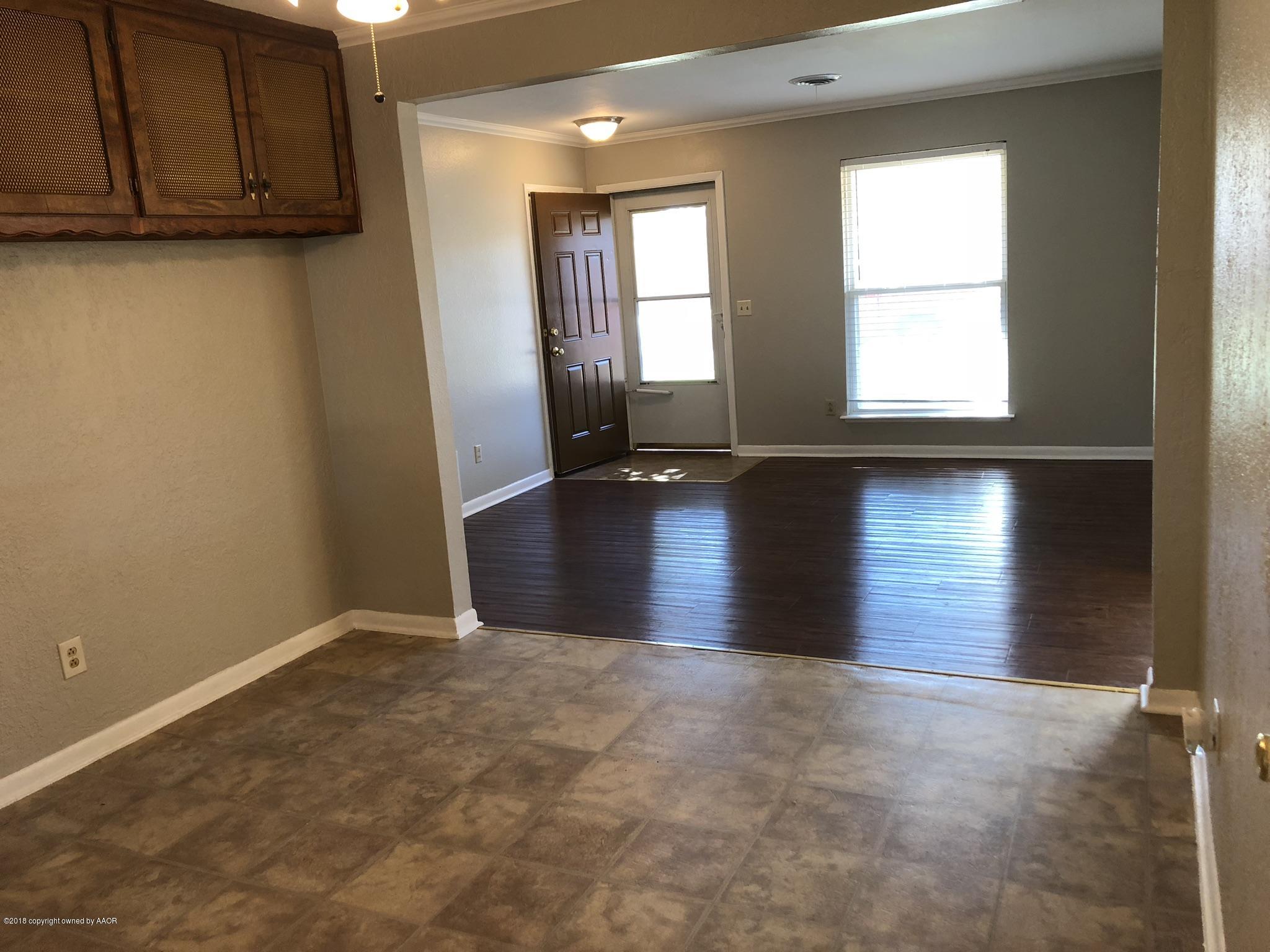 2406 Southwest 49th Avenue Amarillo, TX 79110 - Photo 8 of 38 an empty room with wooden floor and windows