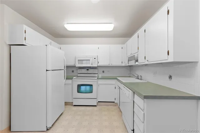 a kitchen with white cabinets and a stove