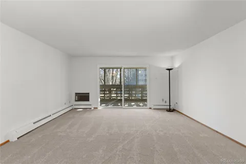 an empty room with floor to ceiling window and an empty room