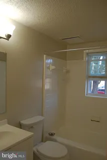 a view of an empty room with closet and a window