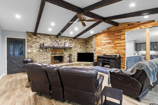 a living room with furniture a fireplace and a flat screen tv