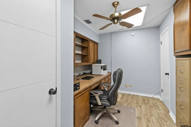 a view of a workspace with furniture and a window