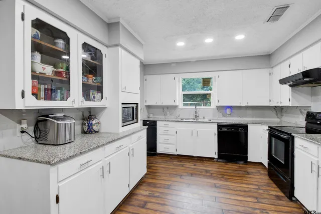 a kitchen with stainless steel appliances granite countertop a refrigerator and a stove top oven