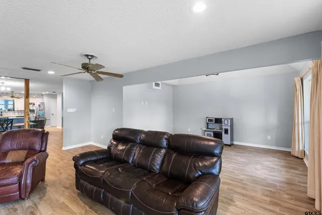 a living room with furniture and a wooden floor