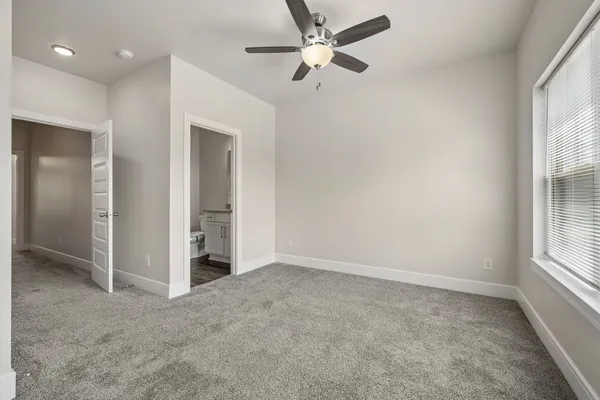 an empty room with fan and windows
