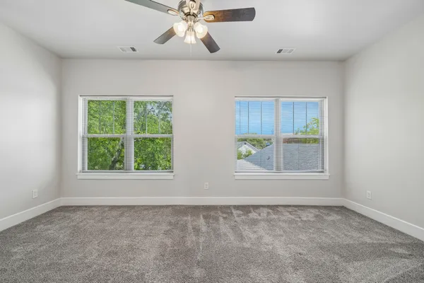 an empty room with a window and a ceiling fan