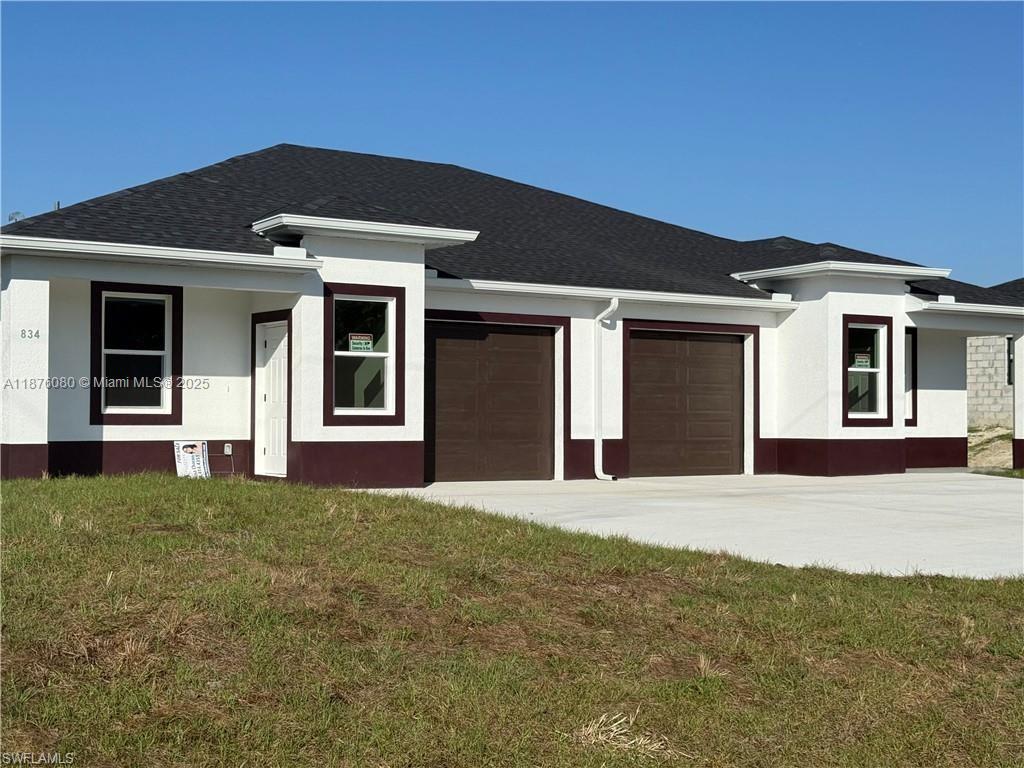 832 Holmes Avenue, Unit 832 Lehigh Acres, FL 33974 - Photo 1 of 24 a front view of a house with a garden