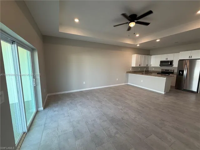 a view of a kitchen with a sink and a refrigerator