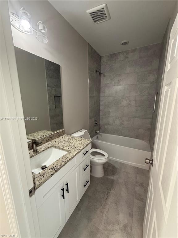 832 Holmes Avenue, Unit 832 Lehigh Acres, FL 33974 - Photo 22 of 24 a bathroom with a granite countertop sink a toilet and shower