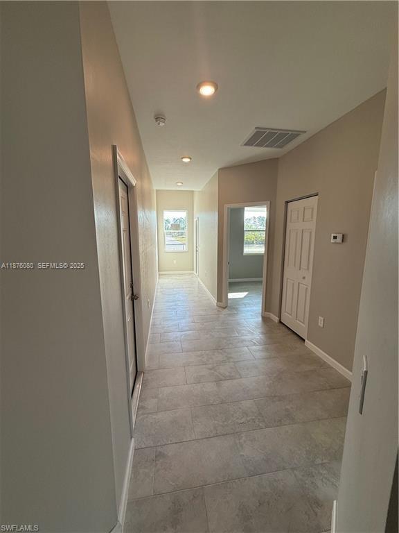 832 Holmes Avenue, Unit 832 Lehigh Acres, FL 33974 - Photo 6 of 24 a view of a hallway with wooden shelves