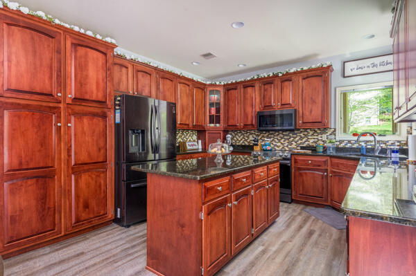 164 Summit Road Swiftwater, PA 18370 - Photo 29 of 42 a kitchen with stainless steel appliances granite countertop a refrigerator a sink dishwasher a stove with wooden cabinets and wooden floor