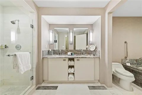 a bathroom with a granite countertop sink a toilet and a mirror