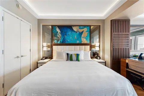 a bedroom with a bed and a painting on the wall