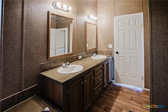 a bathroom with a granite countertop toilet sink and mirror