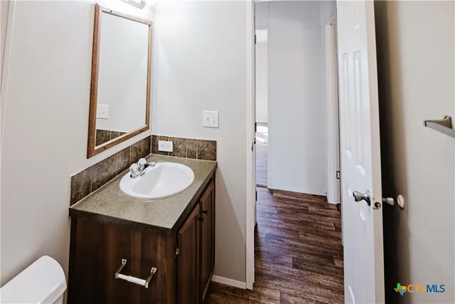 an empty room with windows and chandelier fan