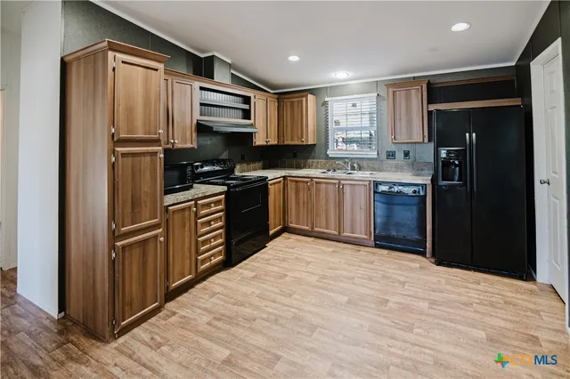 a kitchen with stainless steel appliances granite countertop a refrigerator and a stove