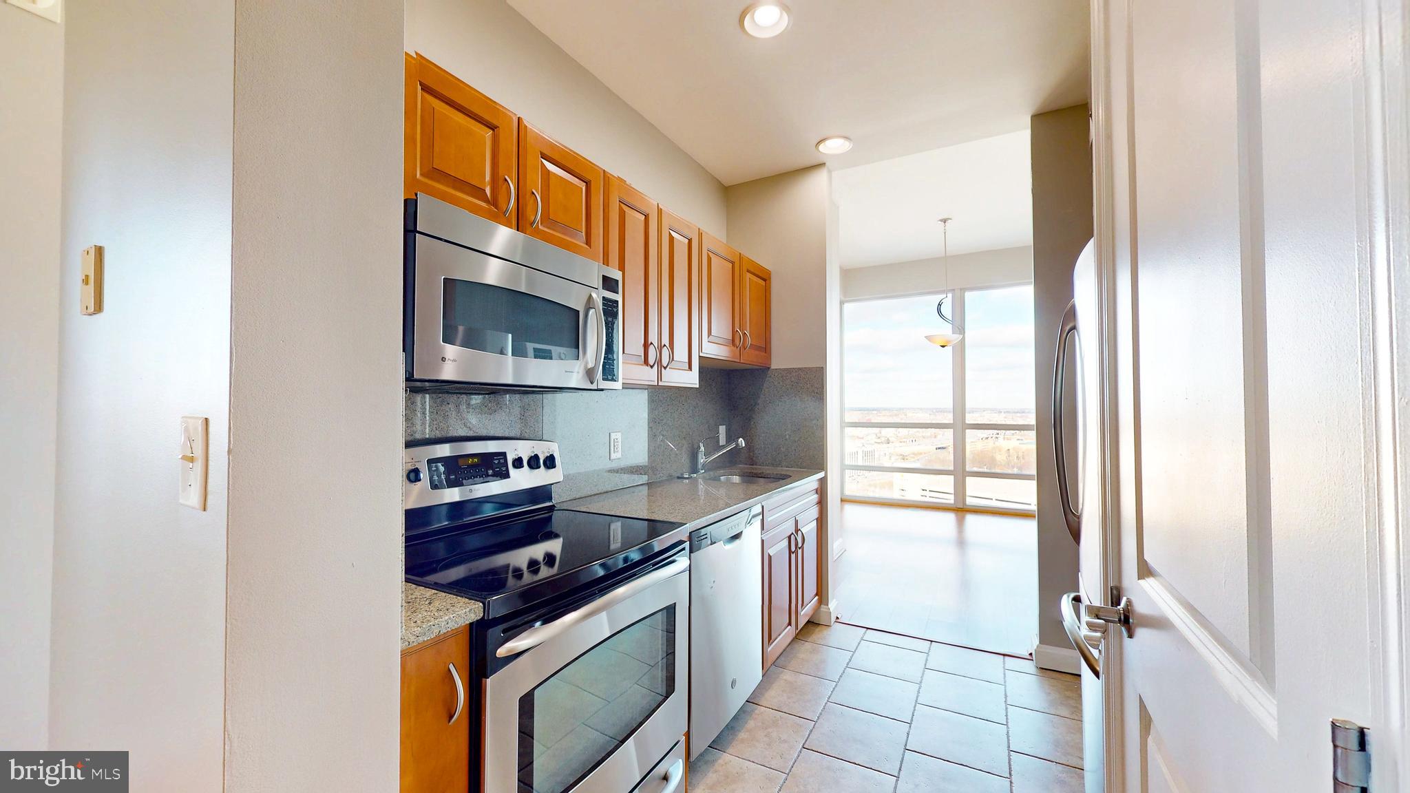 901 North Penn Street, Unit R2404 Philadelphia, PA 19123 - Photo 16 of 29 a kitchen with stainless steel appliances granite countertop a stove a sink and a refrigerator