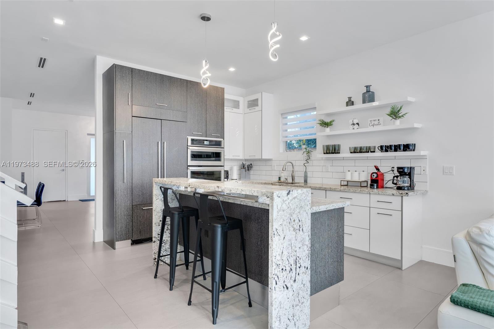 3055 Carter Street, Unit 3055 Miami, FL 33133 - Photo 6 of 32 a kitchen with kitchen island a sink stove and refrigerator