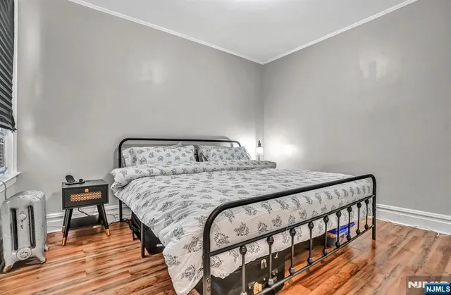 a bedroom with a bed and wooden floor