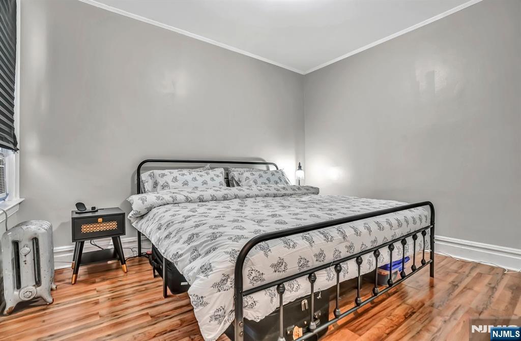 699 Elm Street Kearny, NJ 07032 - Photo 23 of 37 a bedroom with a bed and wooden floor