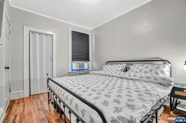 a bedroom with a bed and wooden floor
