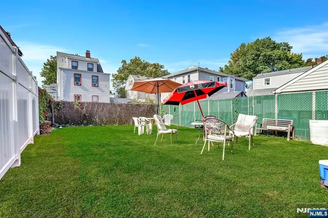 a view of a house with a backyard and chairs