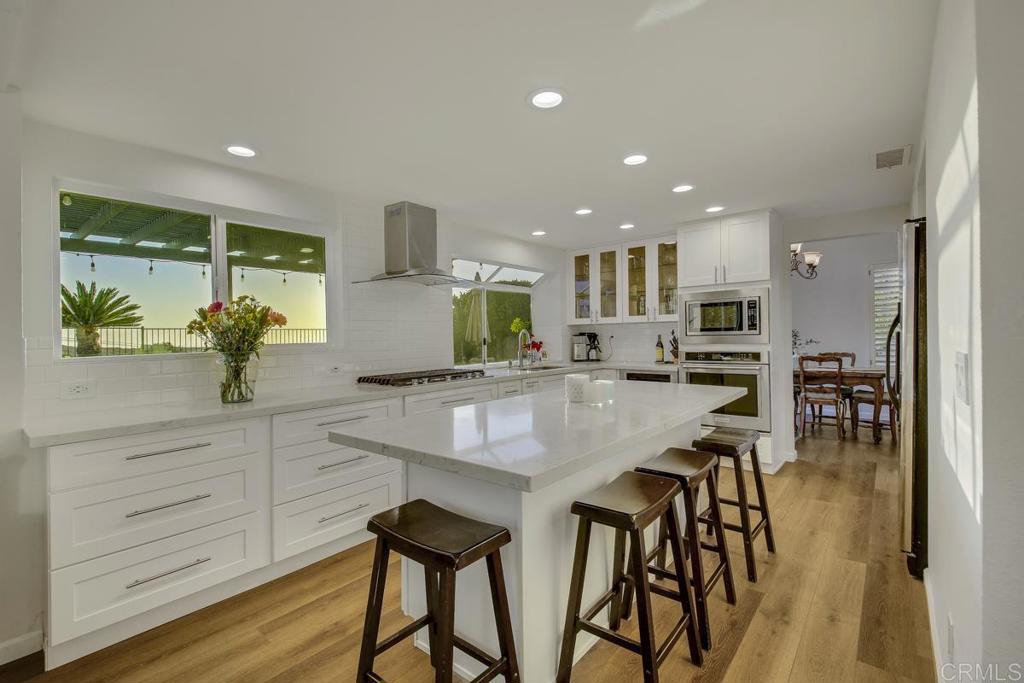 5068 Nighthawk Way Oceanside, CA 92056 - Photo 14 of 39 a kitchen with stainless steel appliances kitchen island granite countertop a table and chairs in it