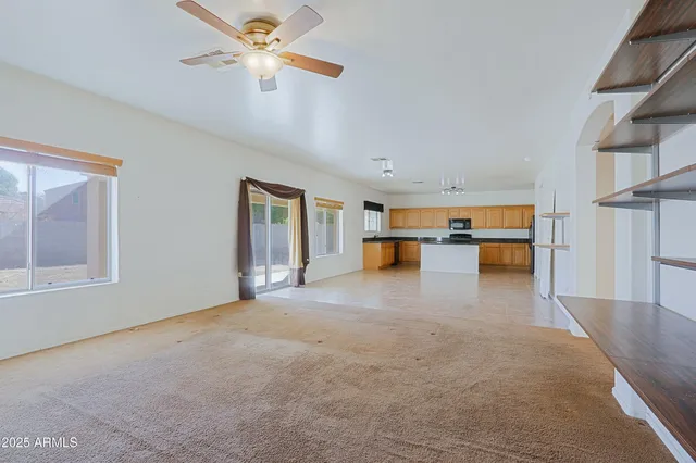 a view of empty room with a kitchen