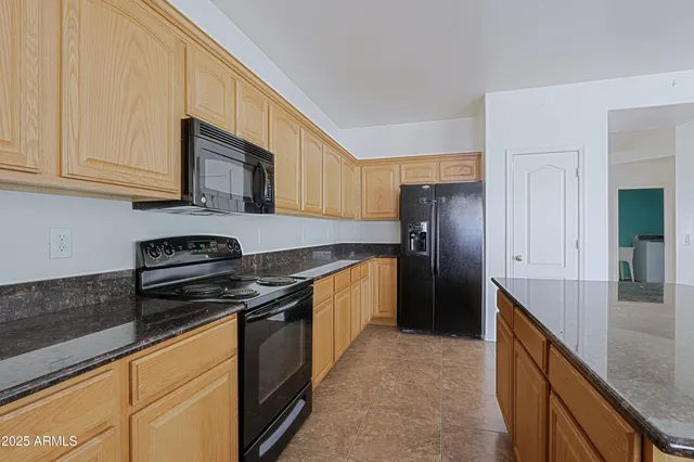 a kitchen with stainless steel appliances granite countertop a stove a refrigerator and a sink
