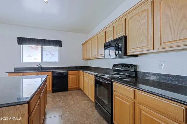 a kitchen with stainless steel appliances granite countertop a sink stove and microwave