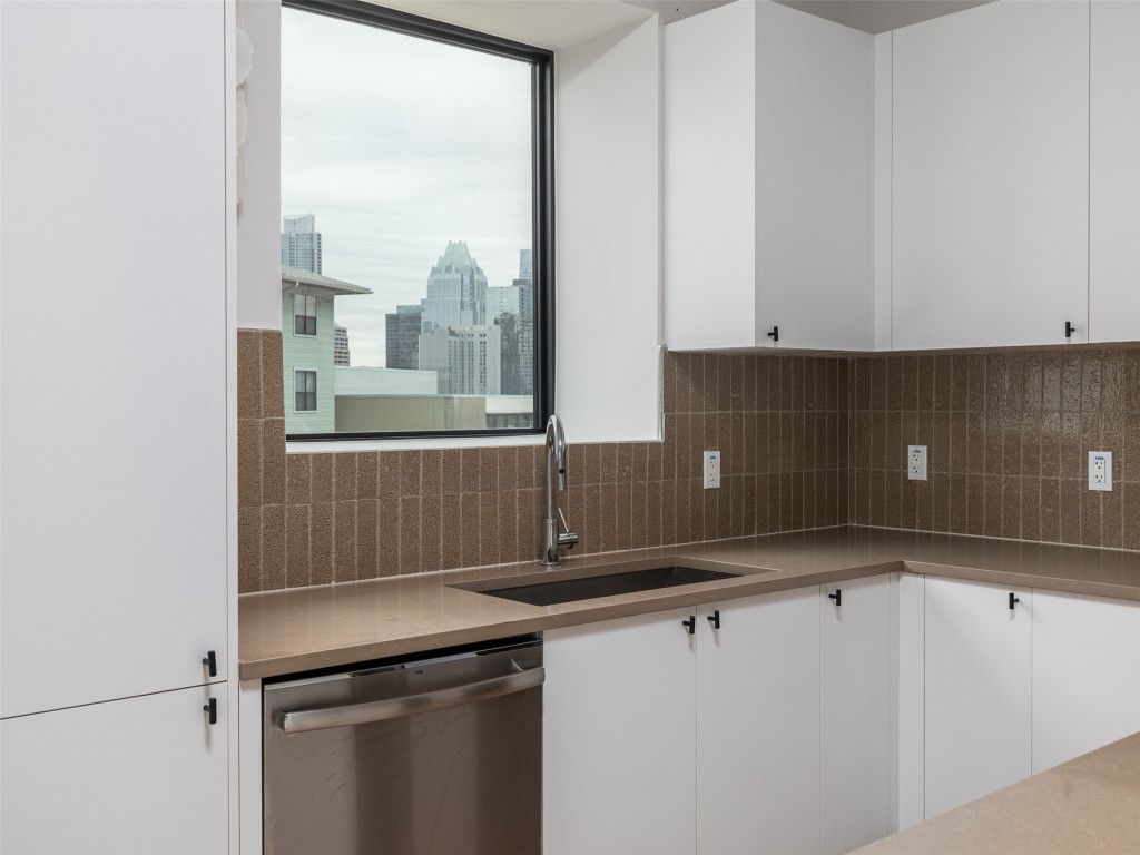800 Embassy Drive, Unit 237 Austin, TX 78702 - Photo 6 of 35 Kitchen with white cabinets, dishwasher, and decorative backsplash
