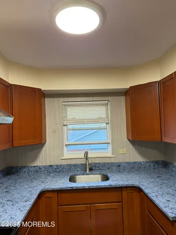 a kitchen with granite countertop a sink a stove and cabinets