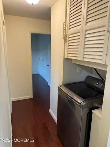 a utility room with wooden floor washer and dryer