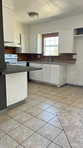 a view of a hallway with wooden floor and a living room