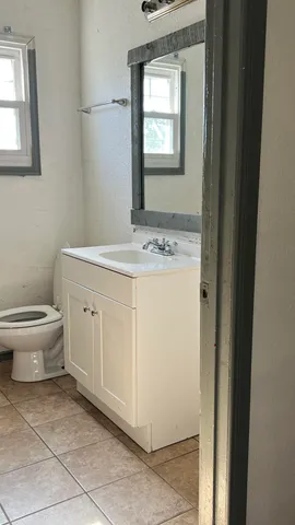 an empty room with a window and a ceiling fan