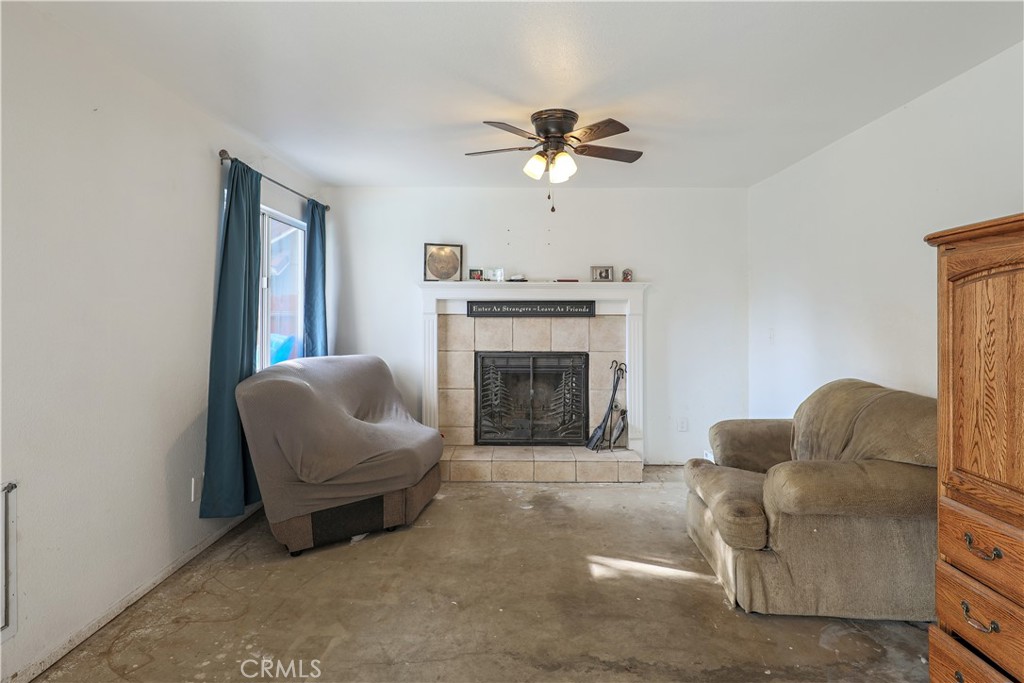 308 Harbor Drive Atwater, CA 95301 - Photo 19 of 58 a living room with furniture a fireplace and a ceiling fan