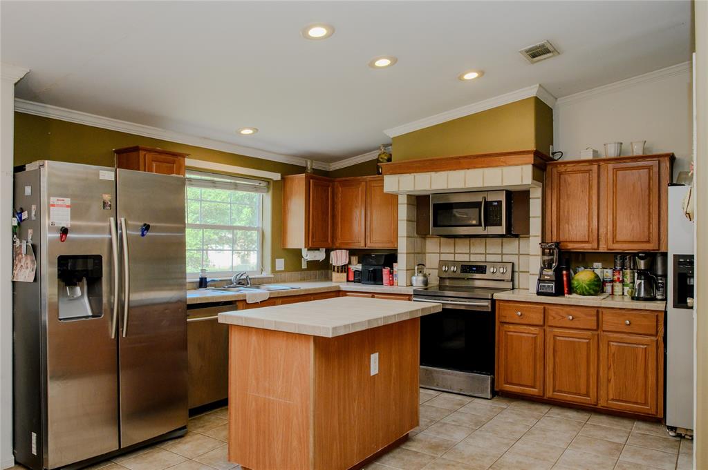 1468 Cedar Mills Road Gordonville, TX 76245 - Photo 11 of 35 a kitchen with stainless steel appliances granite countertop a stove top oven a refrigerator a sink and dishwasher