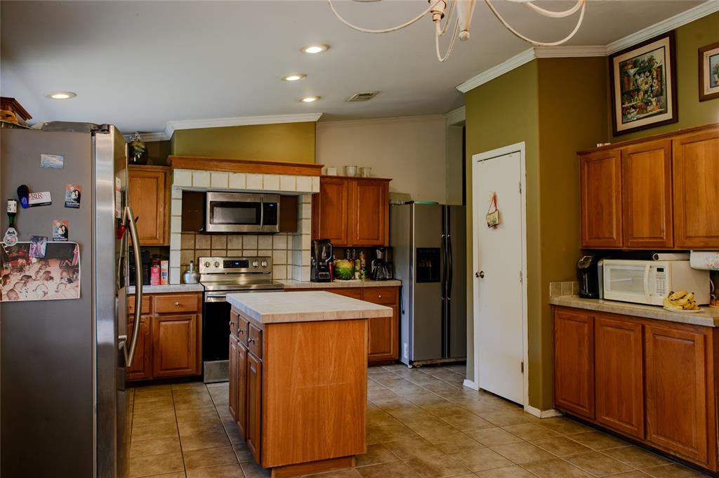 1468 Cedar Mills Road Gordonville, TX 76245 - Photo 12 of 35 a kitchen with stainless steel appliances granite countertop a stove refrigerator and a microwave