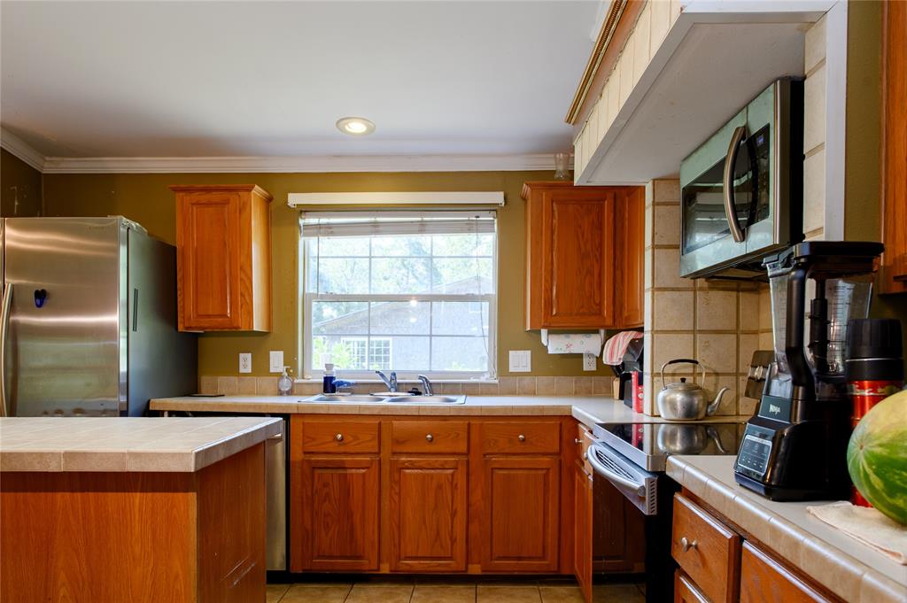 1468 Cedar Mills Road Gordonville, TX 76245 - Photo 13 of 35 a kitchen with granite countertop a sink stove and cabinets