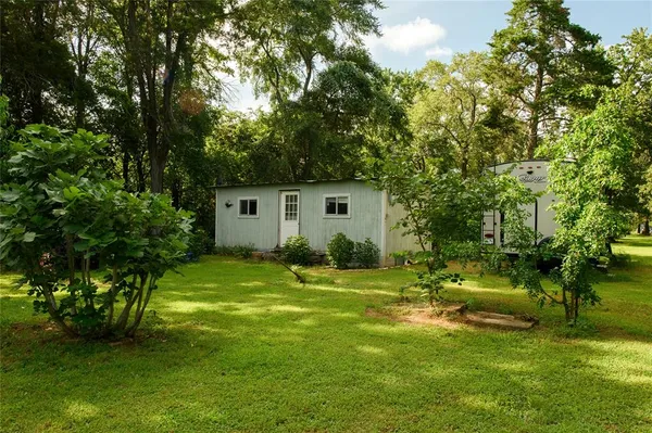 a backyard of a house with garden and trees