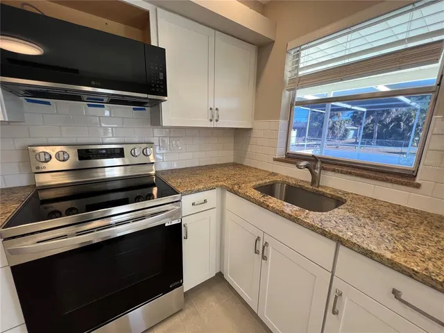 a kitchen with granite countertop a sink and a stove