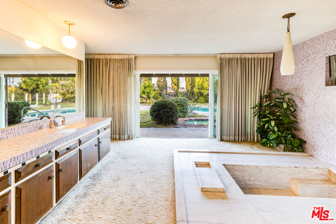 1950 Carla Ridge Beverly Hills, CA 90210 - Photo 16 of 29 a large white kitchen with a large window