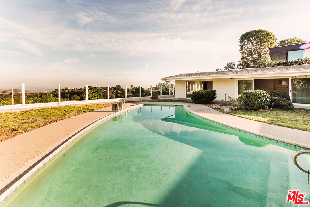 1950 Carla Ridge Beverly Hills, CA 90210 - Photo 22 of 29 a view of a house with a swimming pool